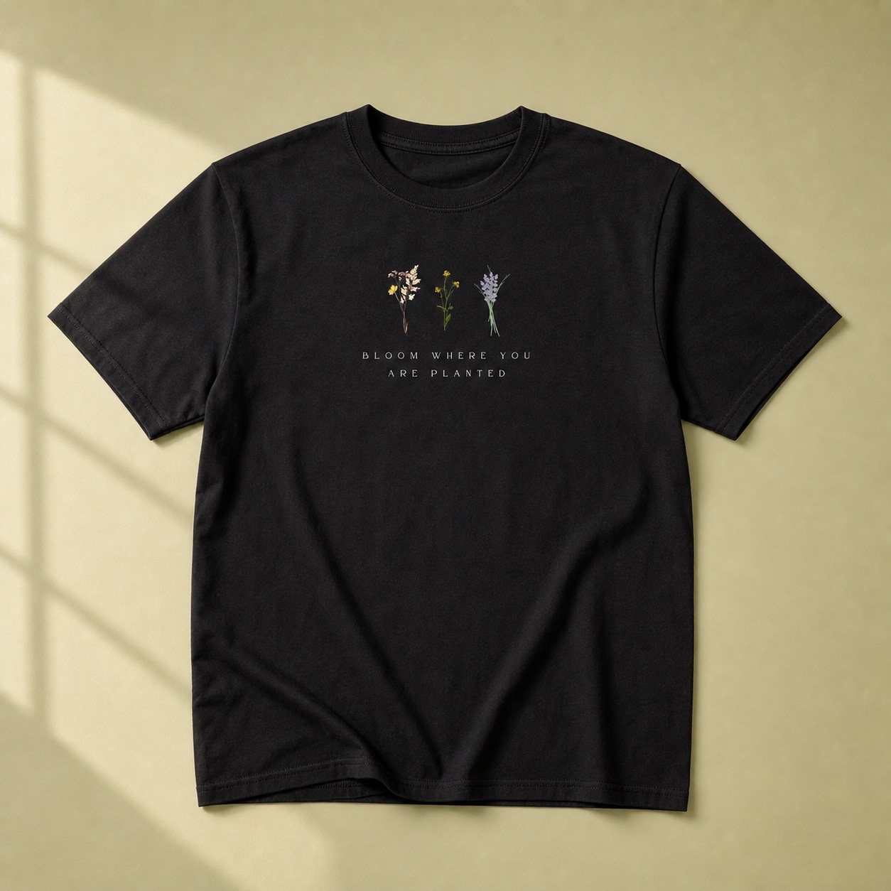La camiseta Bloom negra sobre fondo oliva