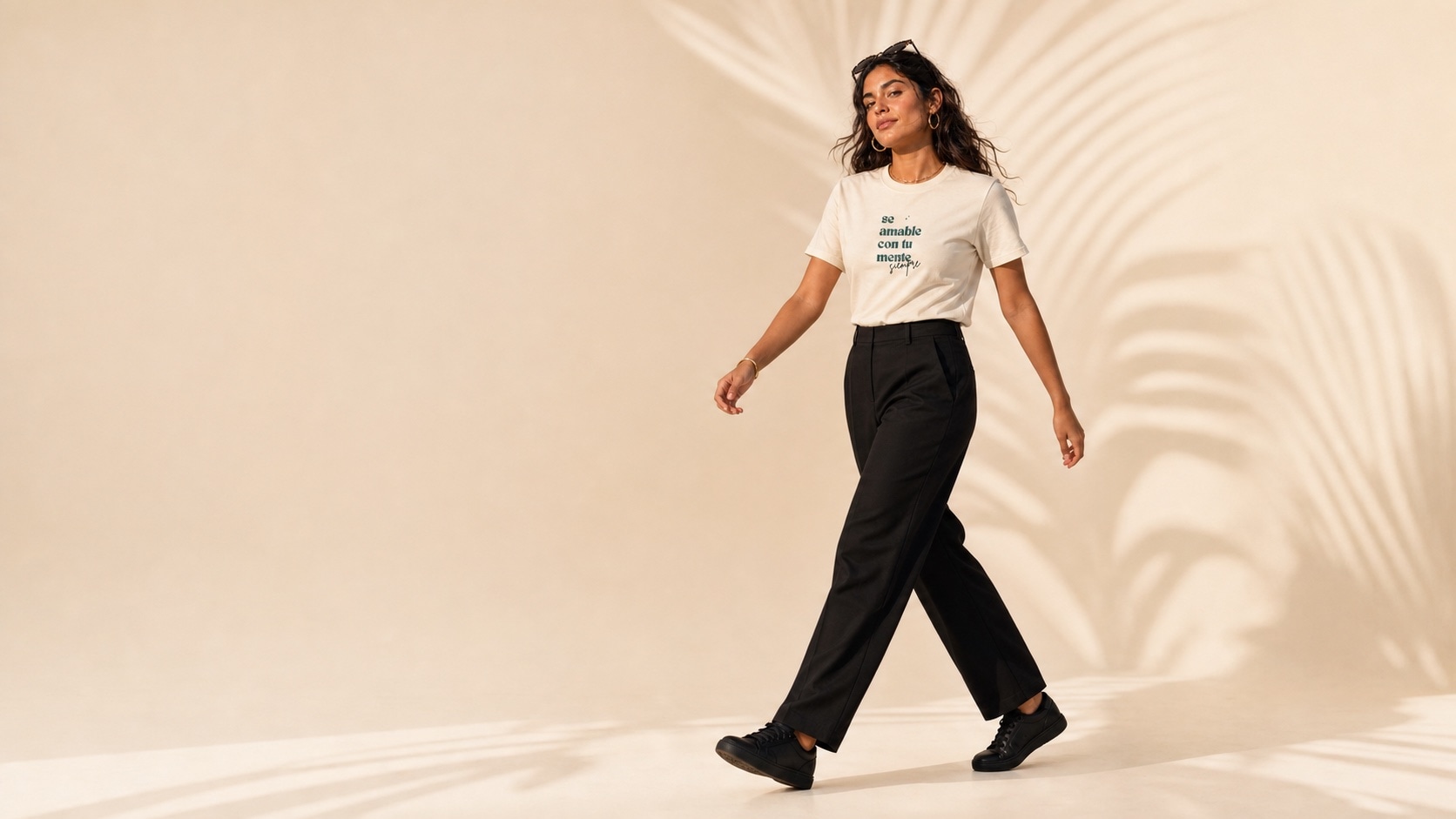 Modelo caminando con la camiseta y pantalón negro